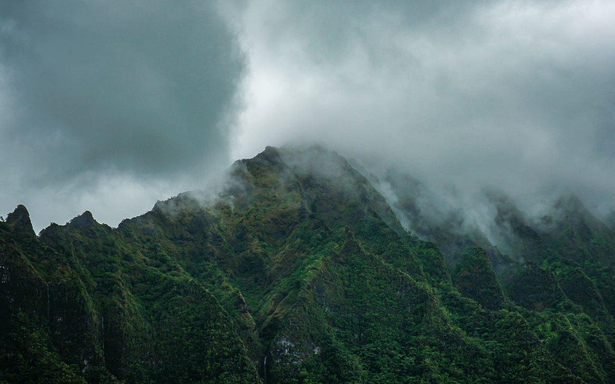 Image of the Ko'olau mountain range of O'ahu, Hawai'i enveloped in clouds in a mood scene of tranquility